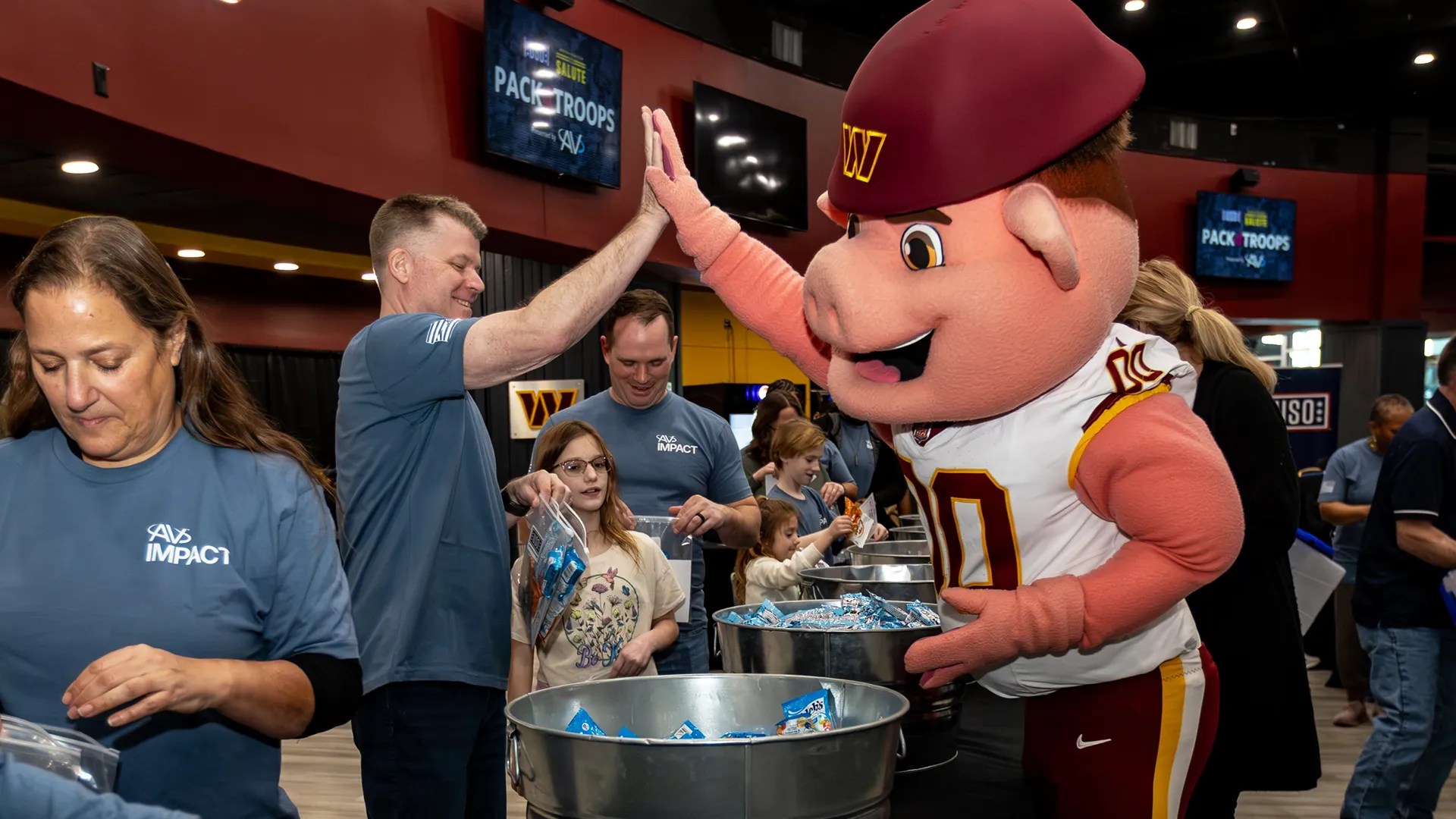 Employee high-fiving a Washington Commanders mascot