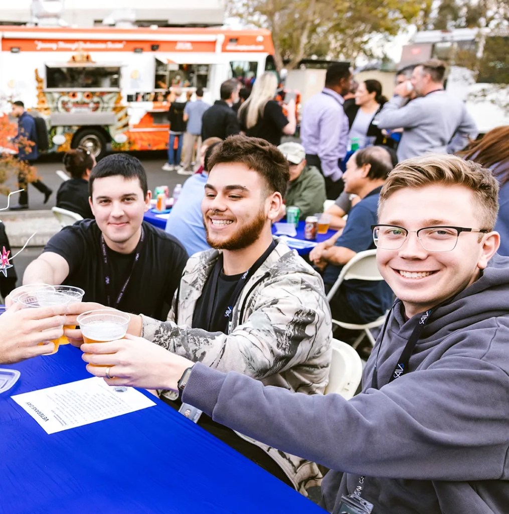 Group of interns posing with a toast holding beverages
