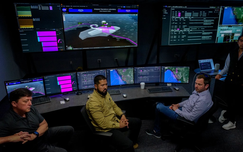 NASA and partners from Aerostar and AeroVironment discuss a simulation of a high-altitude air traffic management system in the Airspace Operations Lab at NASA’s Ames Research Center in California’s Silicon Valley. NASA / Don Richey